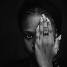 Black woman with one hand over half of face