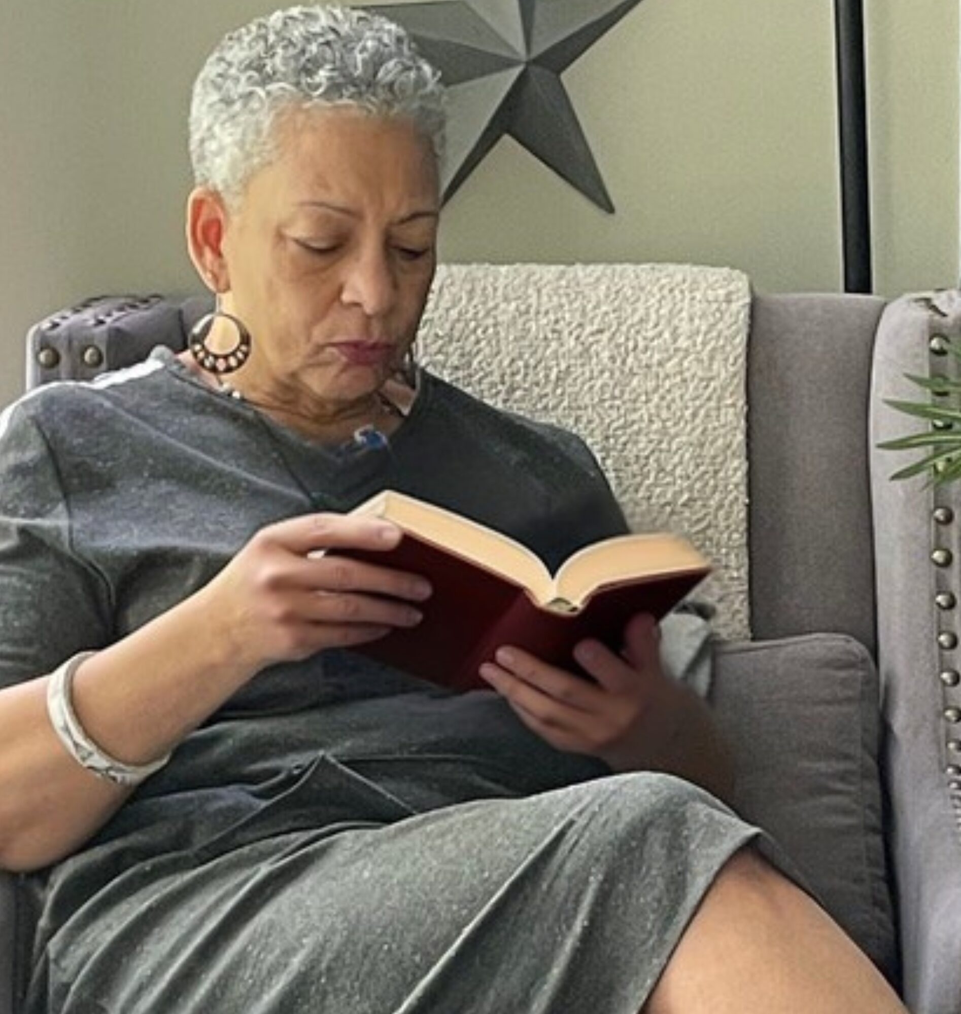 silver hair woman reading a book in a chair